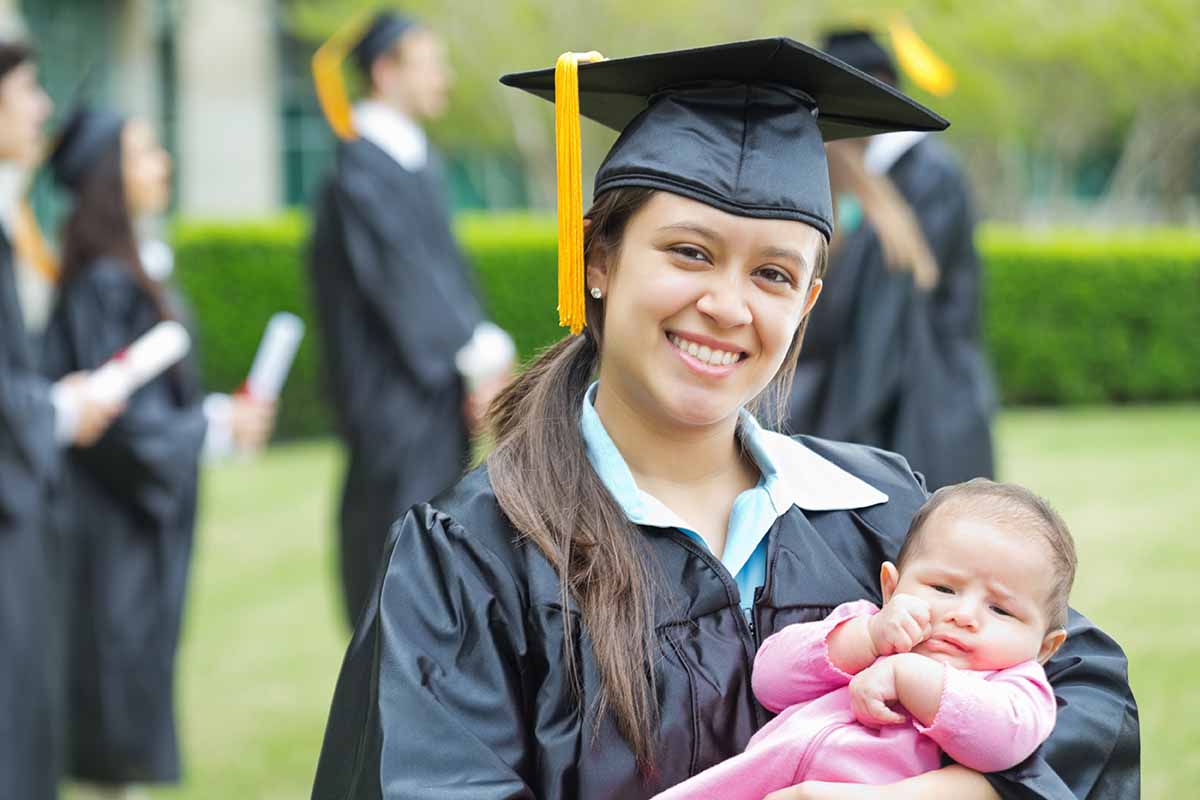 Student Parent holding baby at graduation