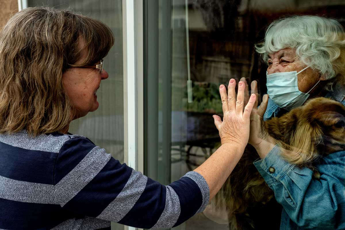 Daughter visits mother during quarantine on other side of glass
