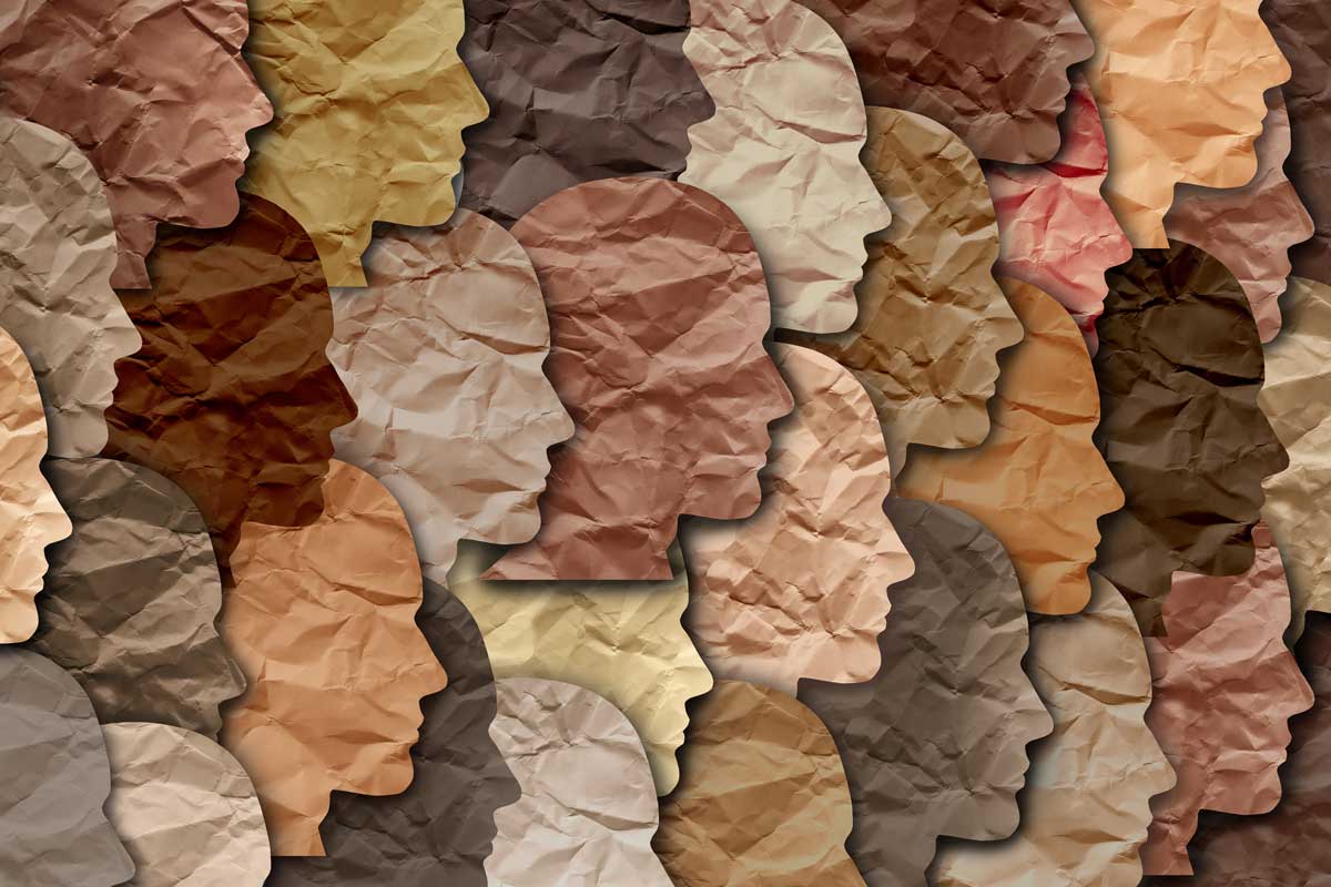 Paper cutouts of faces in profile with a range of skin tones