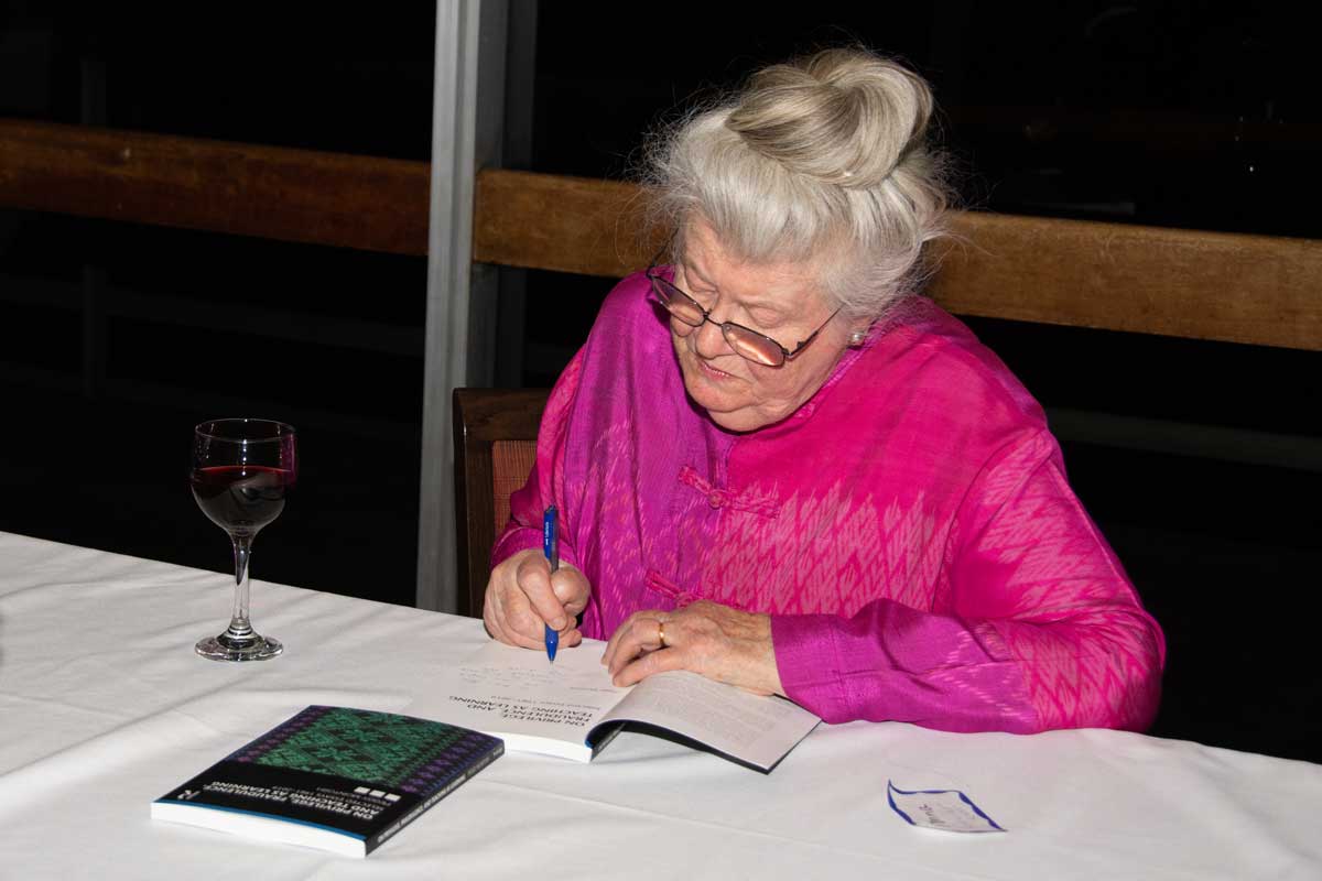 Peggy McIntosh signs a copy of her book, On Privilege, Fraudulence, and Teaching as Learning