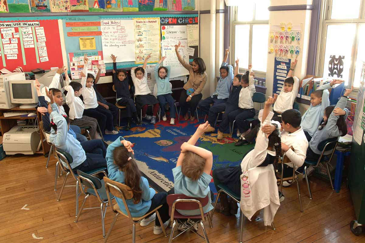 Elementary classroom teacher and students seated in a circle