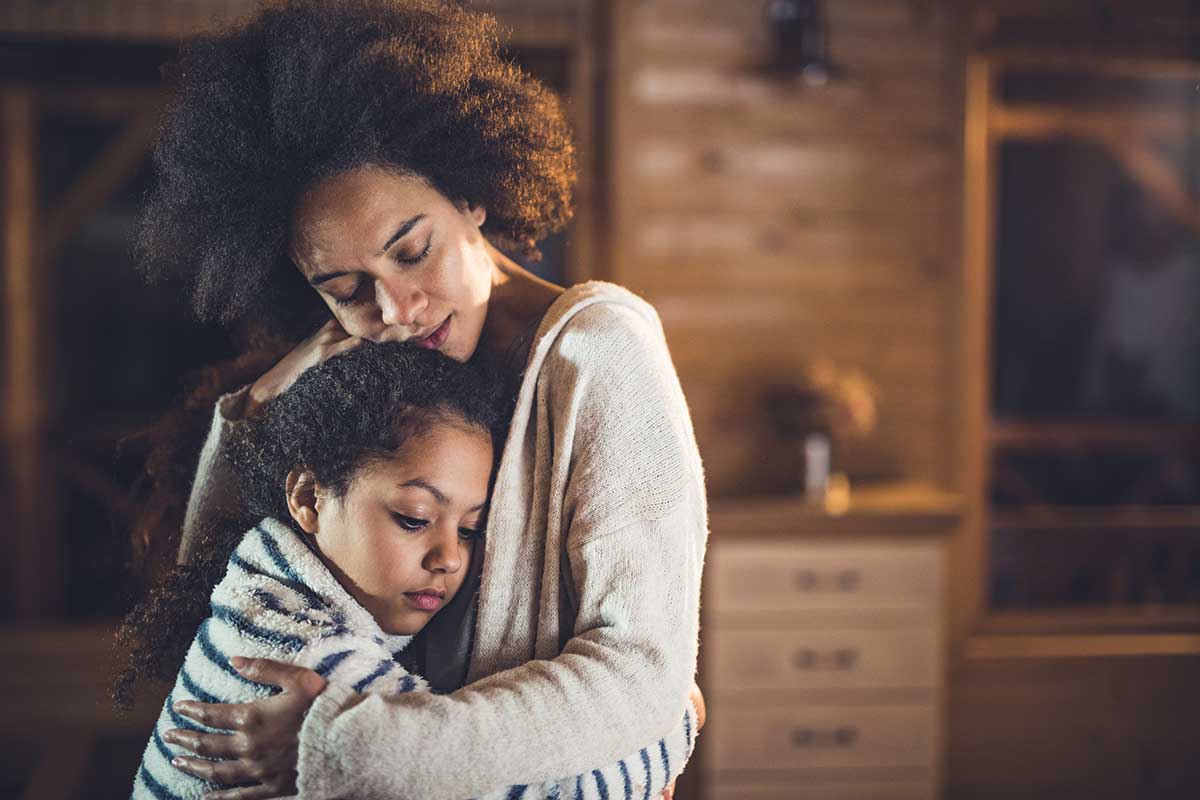 Sad African American mother and child embrace
