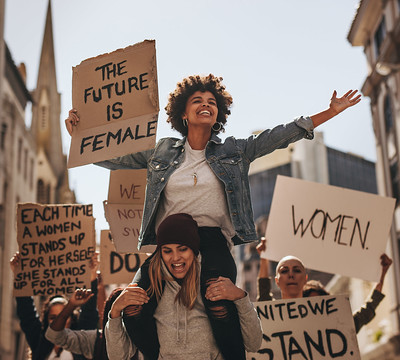 women protesting and holding a "the future is female" sign