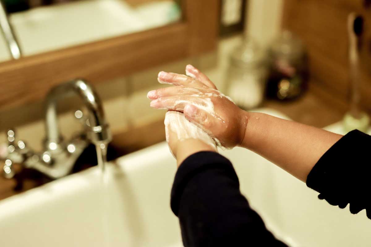 child washing hands with soap and water
