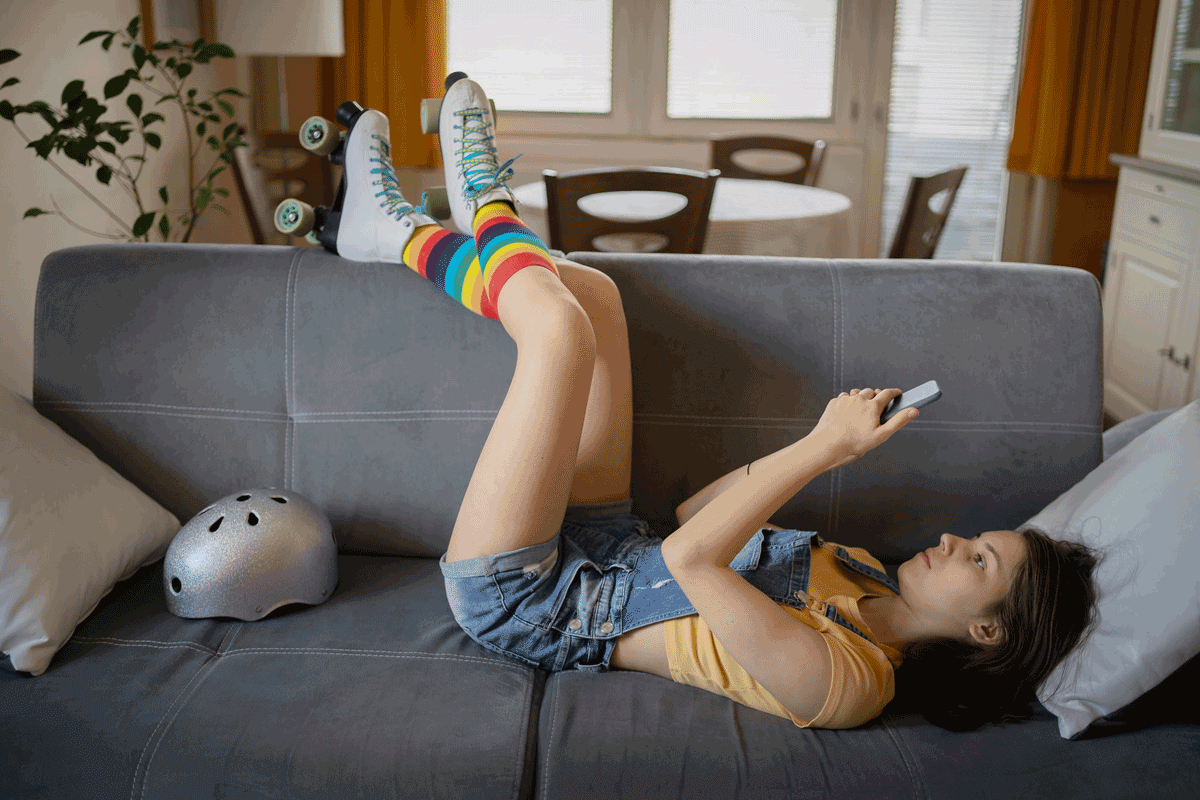 Teen uses smartphone while sitting on couch