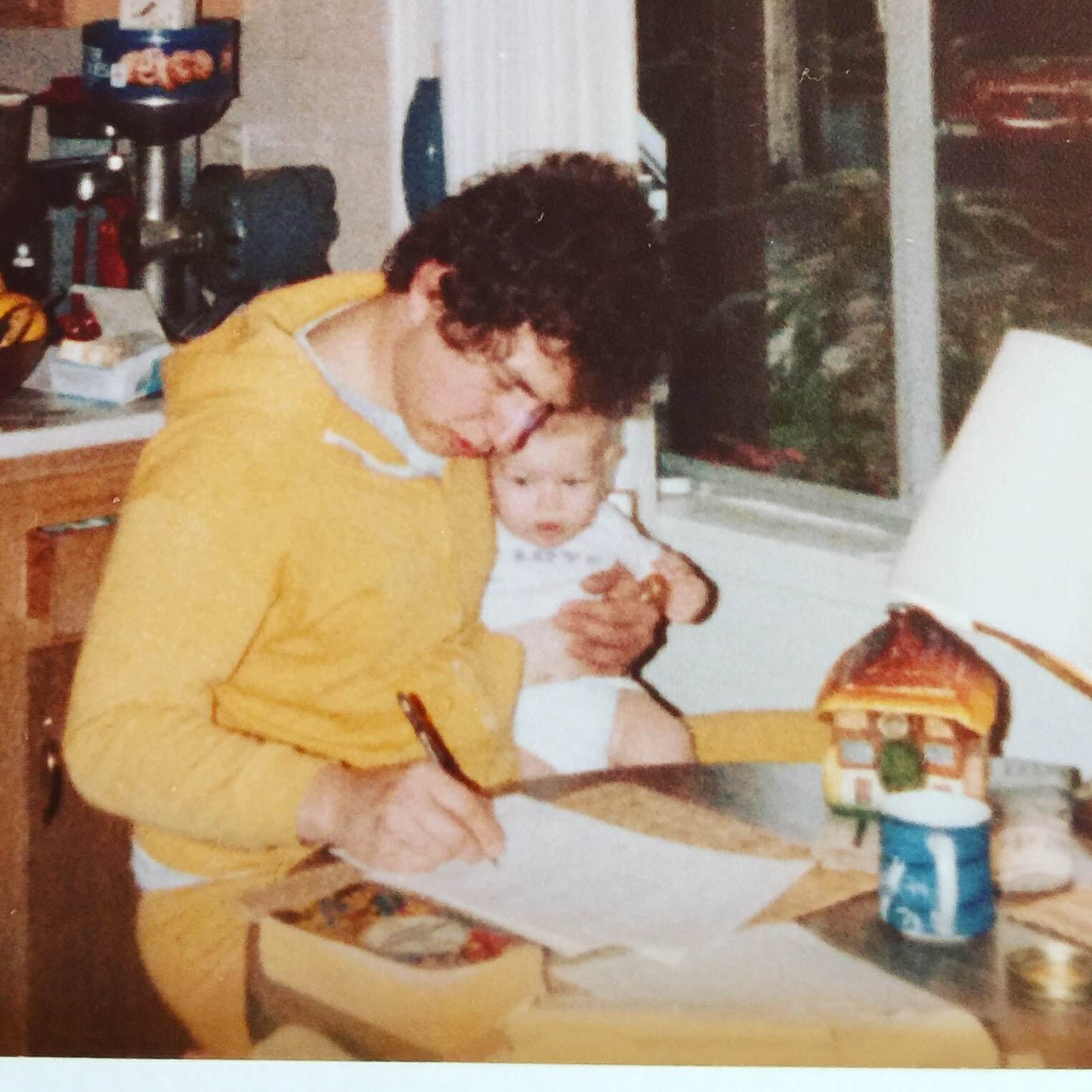 Autumn Green’s dad studying for his med school exams while holding his infant daughter