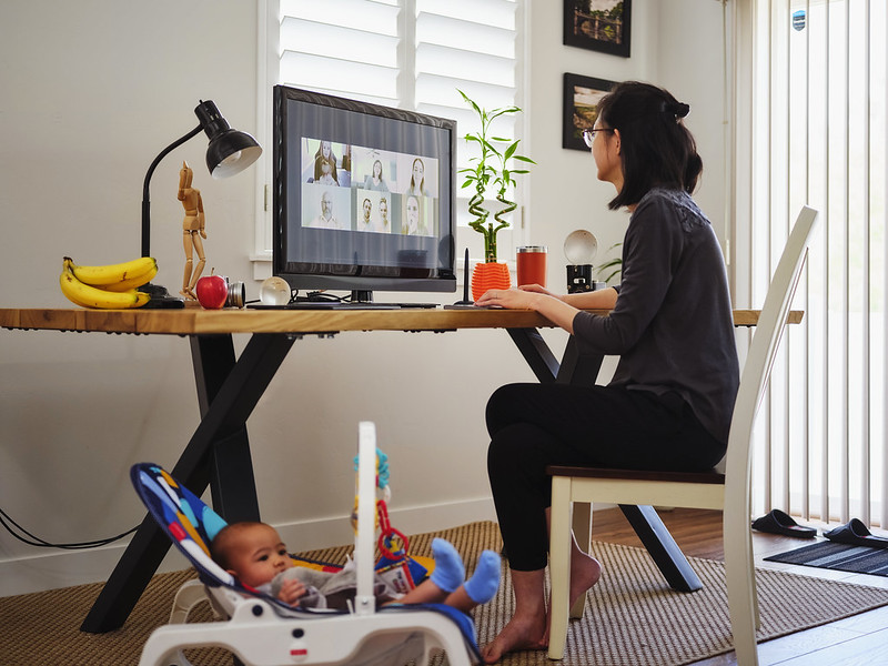 A woman working on a computer with toys scattered around her