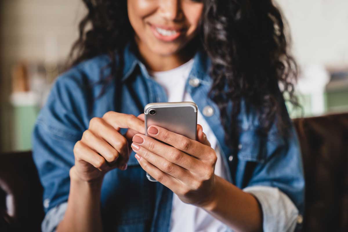 Teen girl of African descent uses smartphone