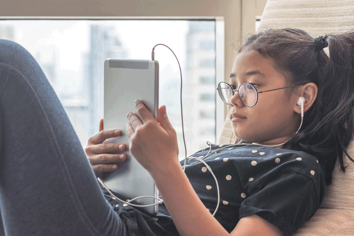 tween girl of asian descent uses a tablet