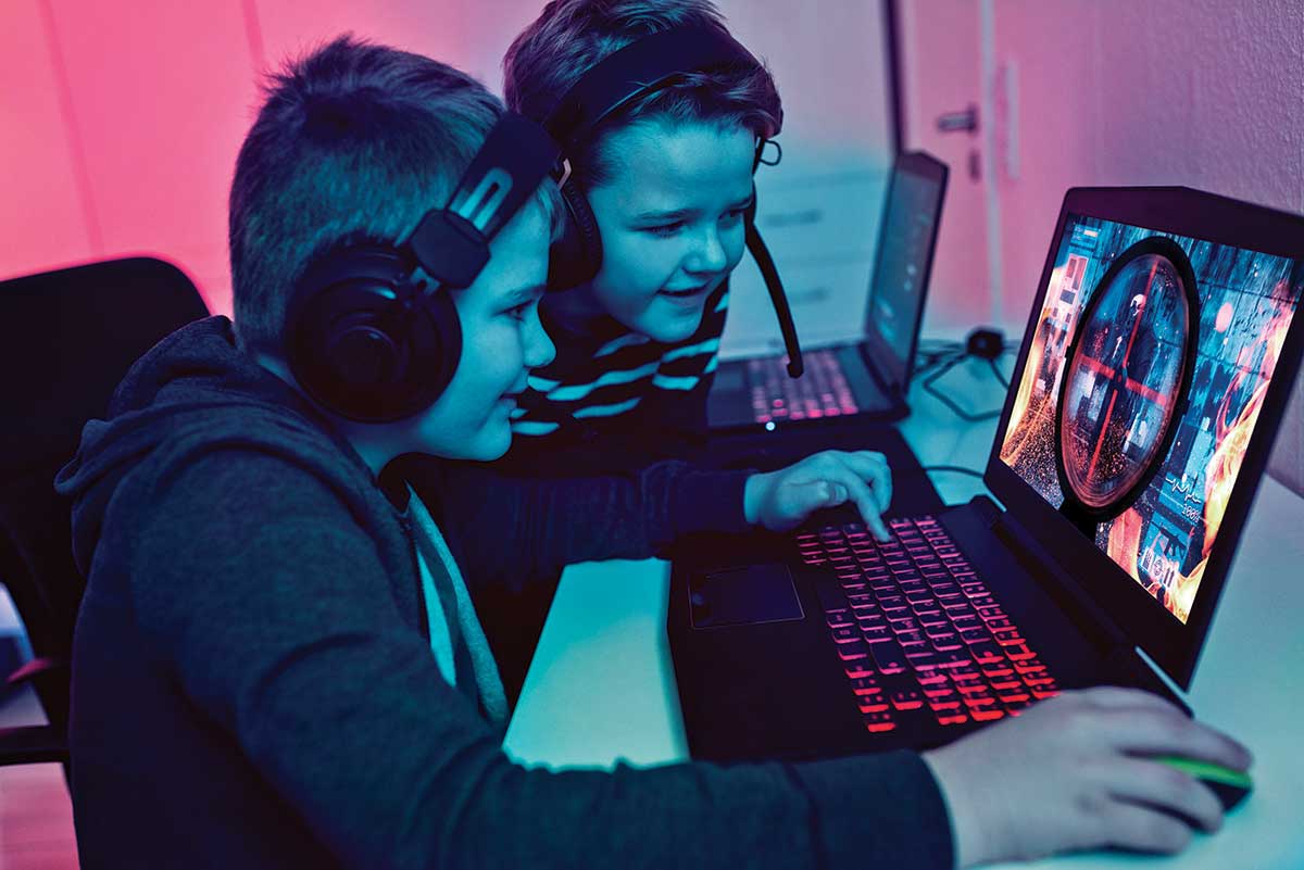 Two middle-school-age boys play a computer game.